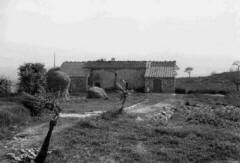 La piccola casa di Casalvento negli anni 50 con la strada a pietra e mucchio di fieno di paglia in una foto in bianco e nero