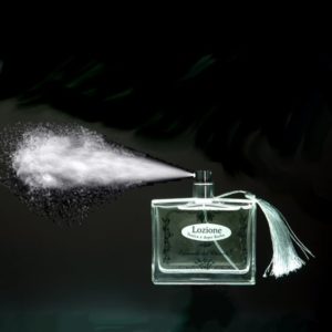 Flacone da profumo in vetro con erogatore naturale spray e penero argento con nube di profumo; etichetta con scritto in nero: Lozione tonica e dopo barba