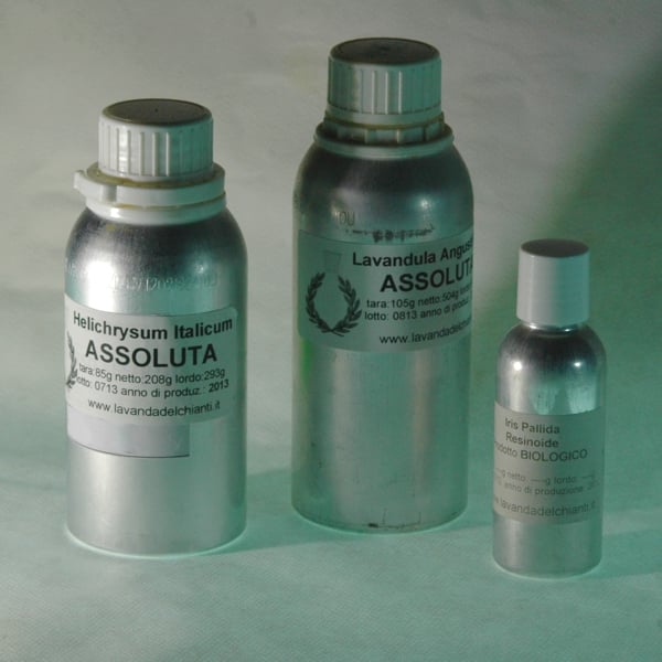 Three aluminum flasks with white plastic caps on a light gray background for storing absolutes and resinoids; labels with writings: Helichrysum absolute, Lavender absolute and Iris Pallida resinoid