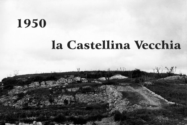 Immagine in bianco e nero degli anni 50 dove una vecchia strada in salita con mura in pietra e rocce sporgenti porta all'abitato etrusco di Castellinaccia chiamata un tempo Salingolpe; scritta nera: Castellina Vecchia