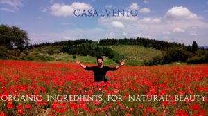 Alessandro Domini in un campo di papaveri rossi sullo sfondo di una collina con un vigneto del Chianti