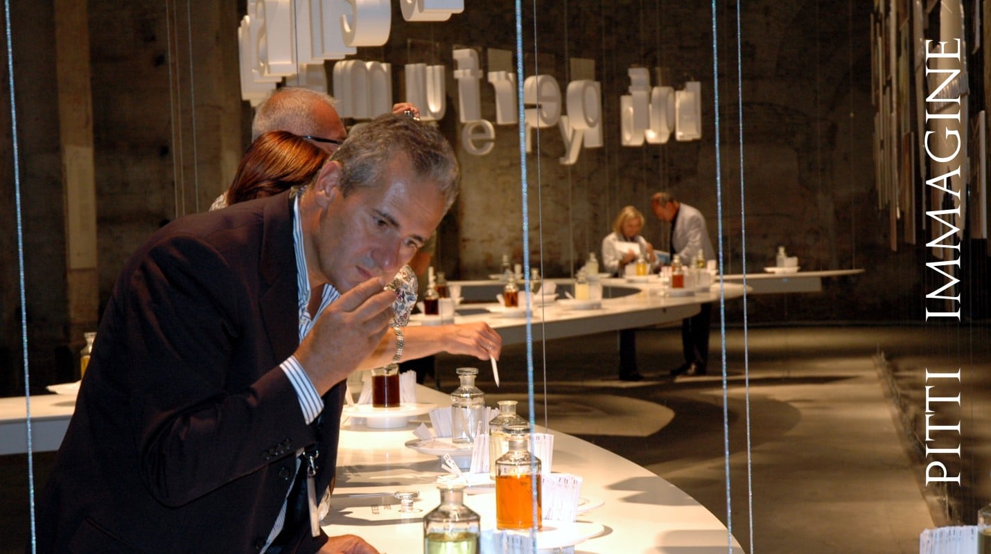 Lorenzo Domini tests a perfumed blend at Fragranze on a white table in a large brown room
