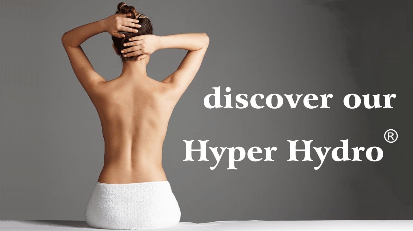 Schiena nuda di una ragazza in un centro benessere su lettino e sfondo grigio, scritta Hyper Hydro