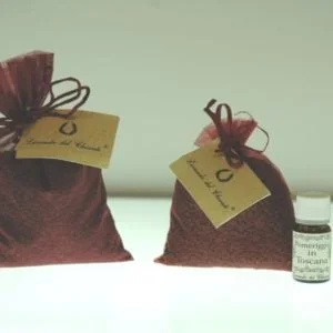 Sacchetto marrone di semi di uva con etichetta e due flaconi di oli essenziali su sfondo chiaro