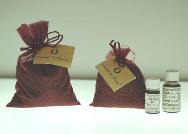 Brown bag of grape seeds with a label and two bottles of essential oils on a light background