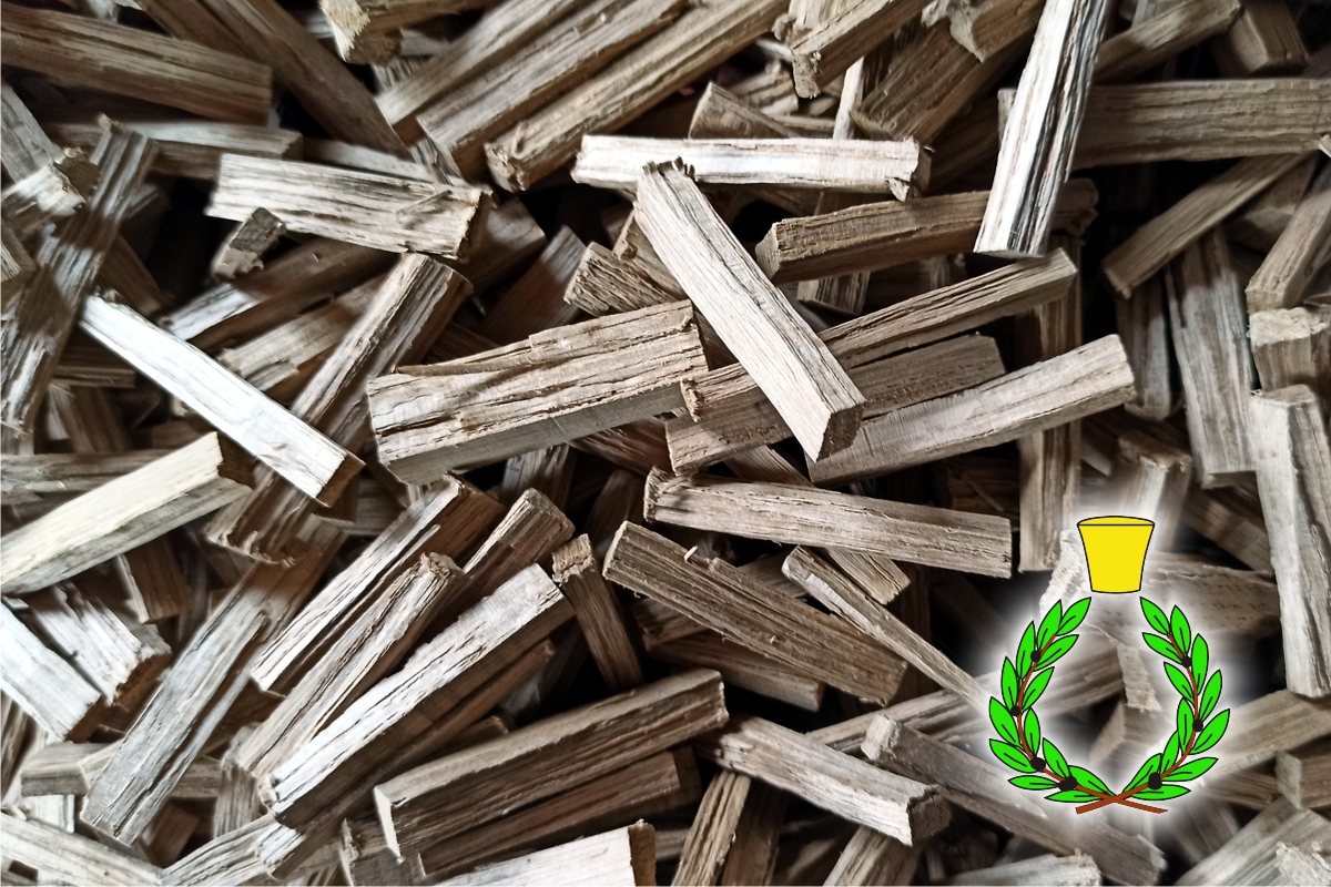 Small gray pieces of oak wood ready for solvent extraction and green and yellow color symbol of Casalvento